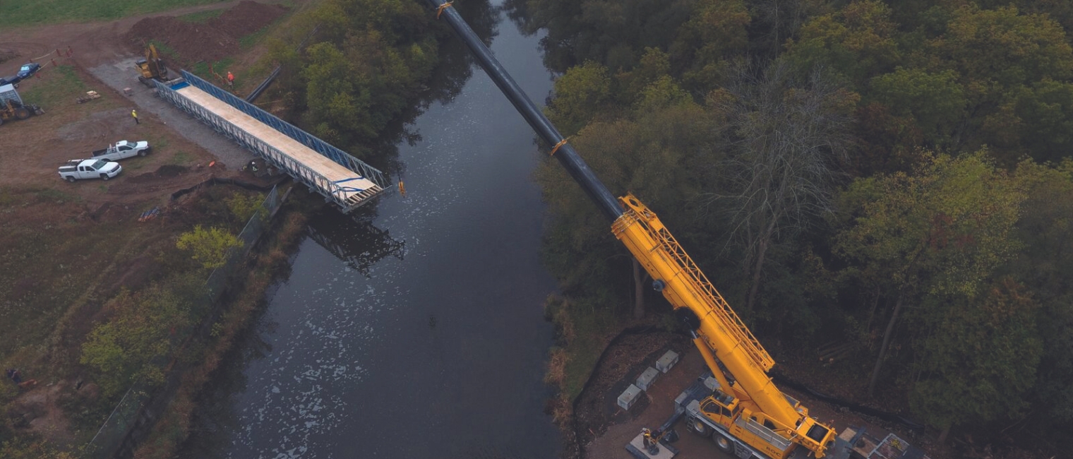 Carrying Utility Pipes Across the Speed River in Cambridge, Ontario